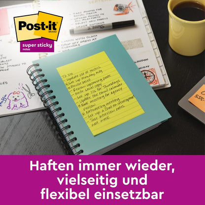 En grön anteckningsbok med ett gult Post-it® Super Sticky Notes i storformat, linjerat (102 mm x 152 mm, 45 blad, 100% PEFC) från 3M Deutschland GmbH ligger på ett skrivbord; den tyska texten noterar extra stark vidhäftning för dina viktigaste påminnelser.