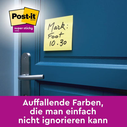 En gul Post-it® Super Sticky Note (76 mm x 76 mm, 90 blad/block) från 3M Deutschland GmbH med texten "Mark: Foot 10.30" är fastklistrad på en blå dörr. Logotypen är synlig och den tyska texten understryker dess synlighet.