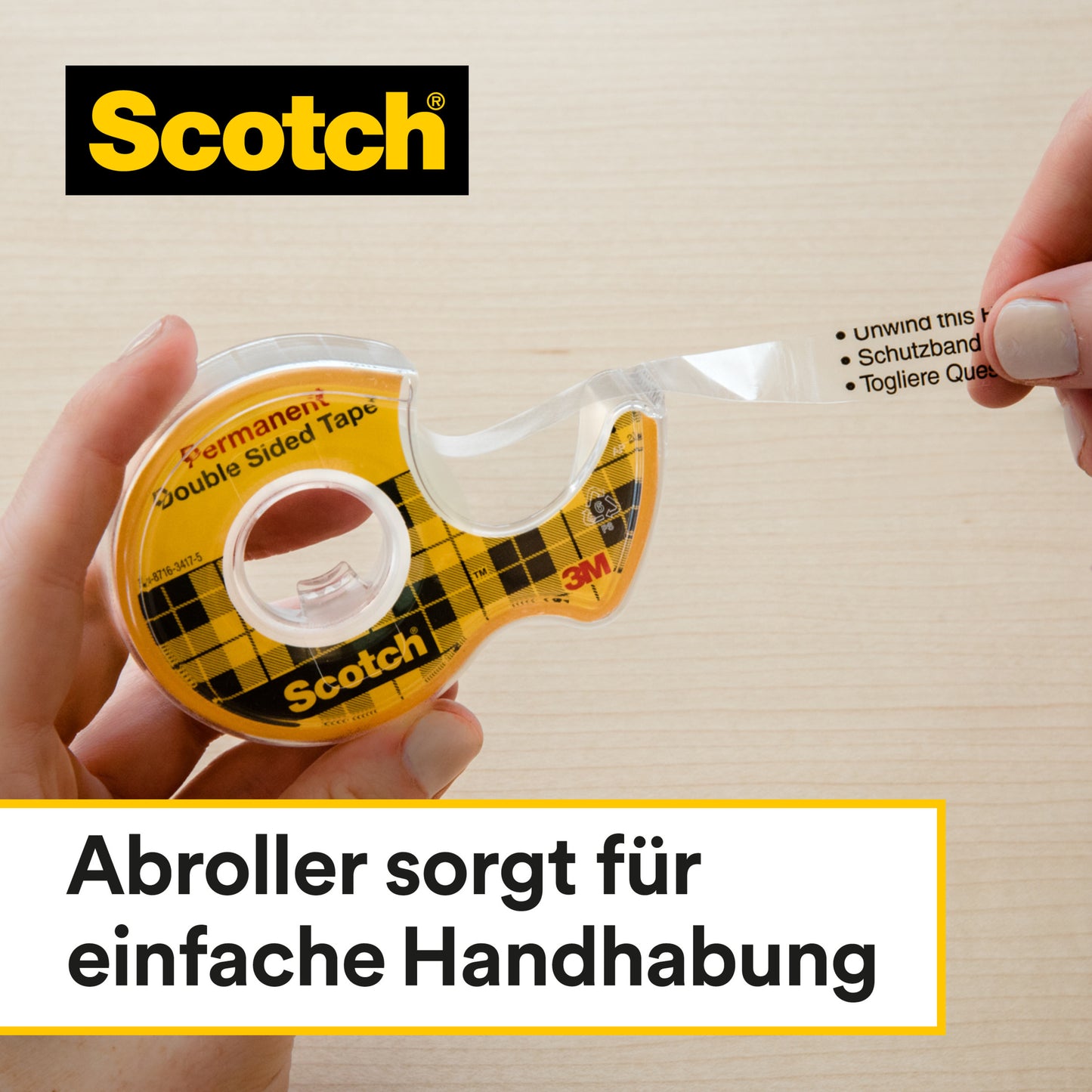 Eine Hand zieht ein 12 mm x 33 m großes Scotch® doppelseitiges Klebeband aus seinem gelben Abroller der 3M Deutschland GmbH auf einer hellen Holzoberfläche. Der deutsche Text lautet: "Abroller sorgt für einfache Handhabung.
